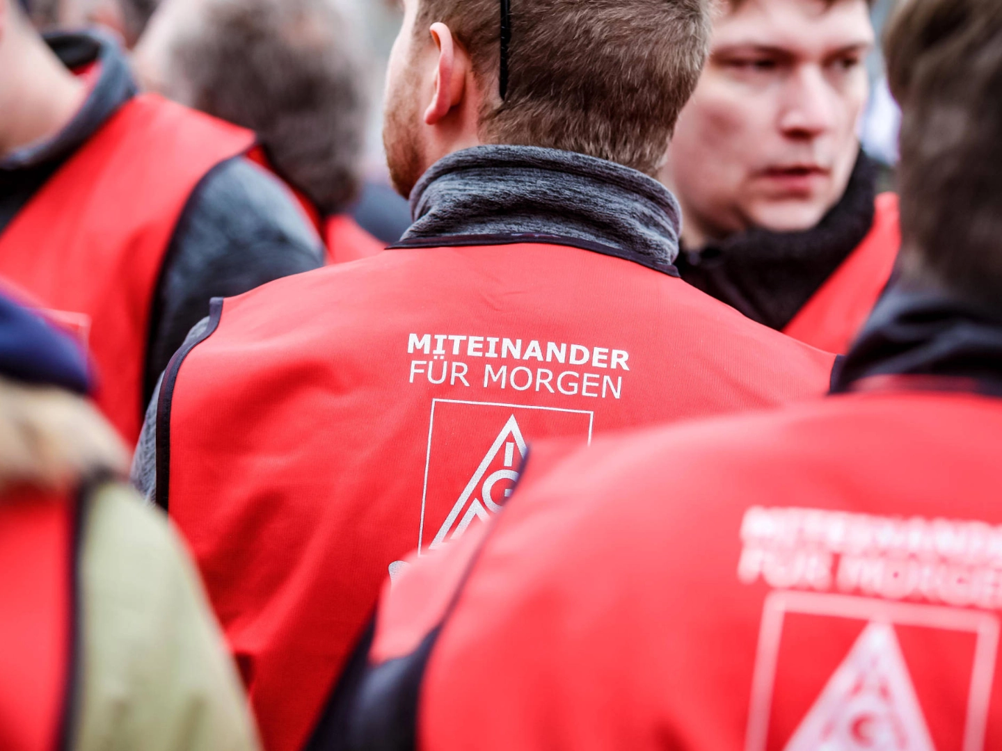Ein Mann mit einer roten Weste, auf der "miteinander für morgen" steht.