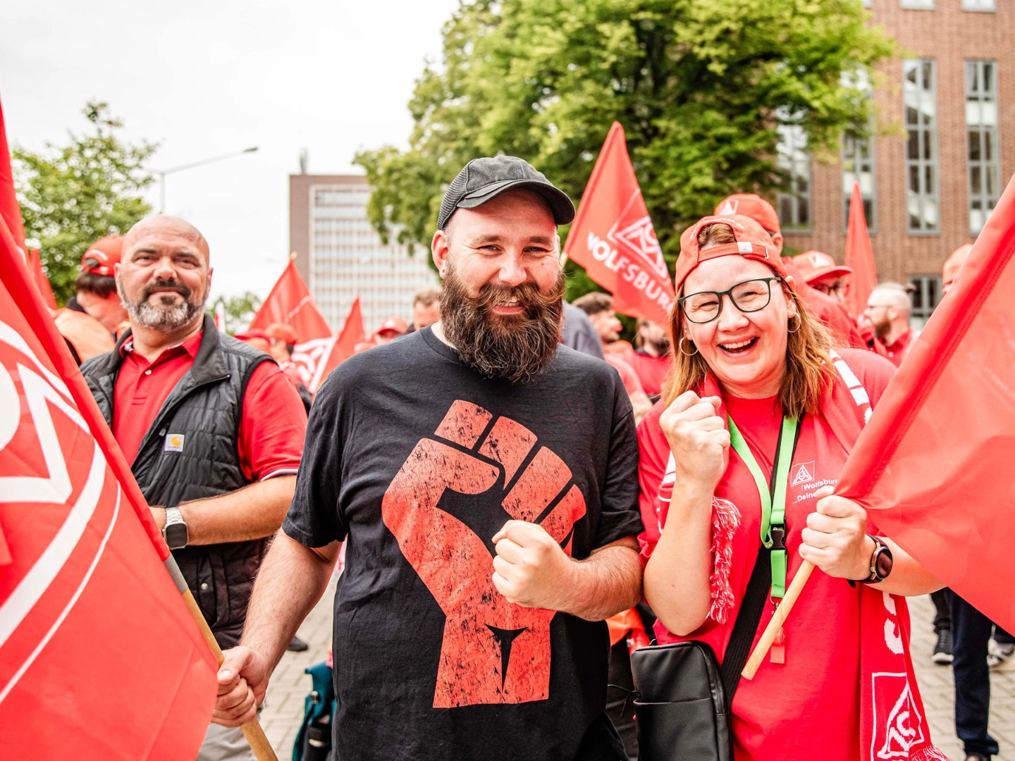 Ein Mann und eine Frau mit IG Metall-Fahnen beim Automobil-Aktionstag bei VW am 09.07.2026 in Wolfsburg