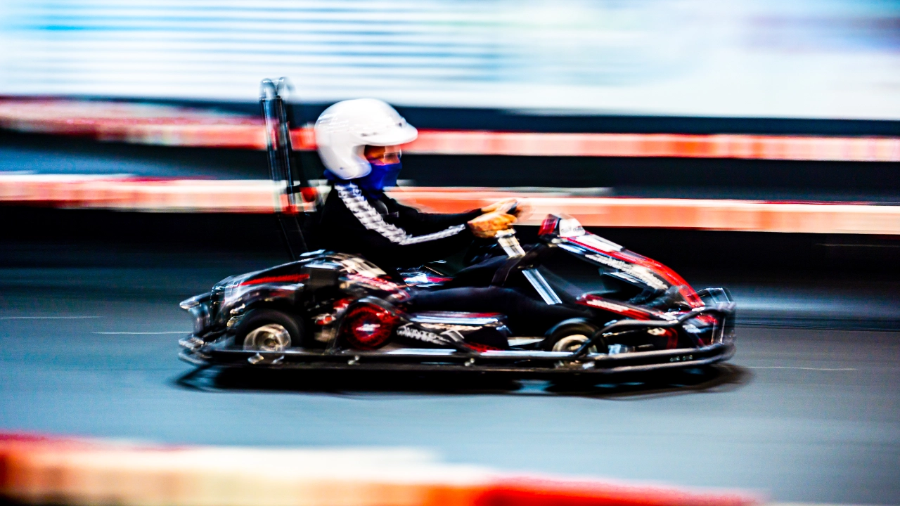 Ein Auszubildender fährt Kart auf Indoorstrecke
