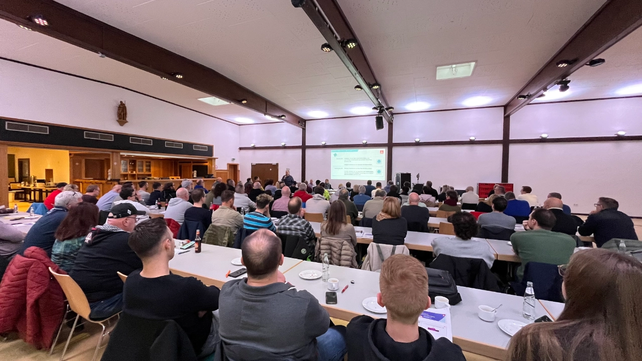 Ein Raum voller Menschen die Andre Arenz bei seinem Vortrag zuhören