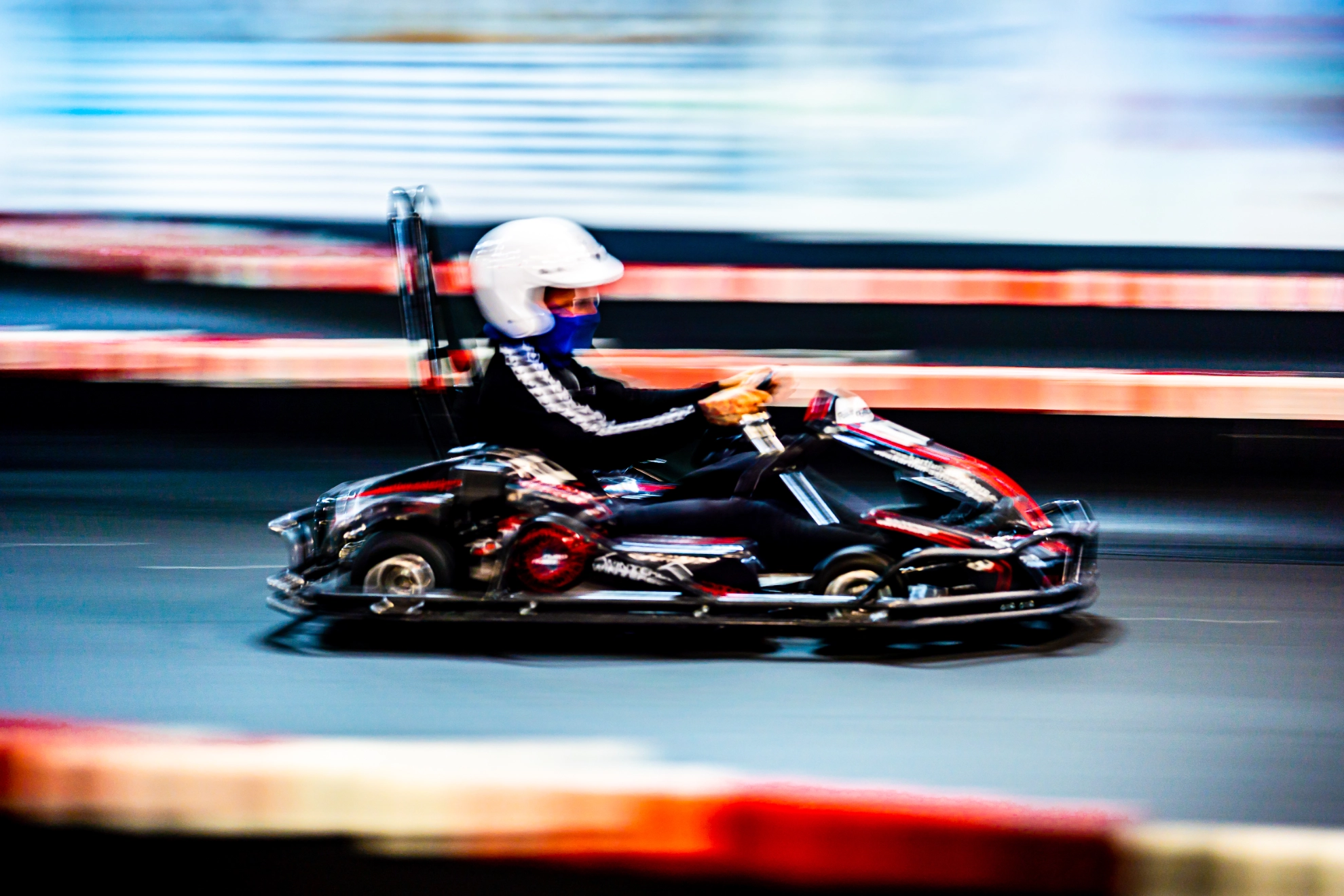 Ein Auszubildender fährt Kart auf Indoorstrecke