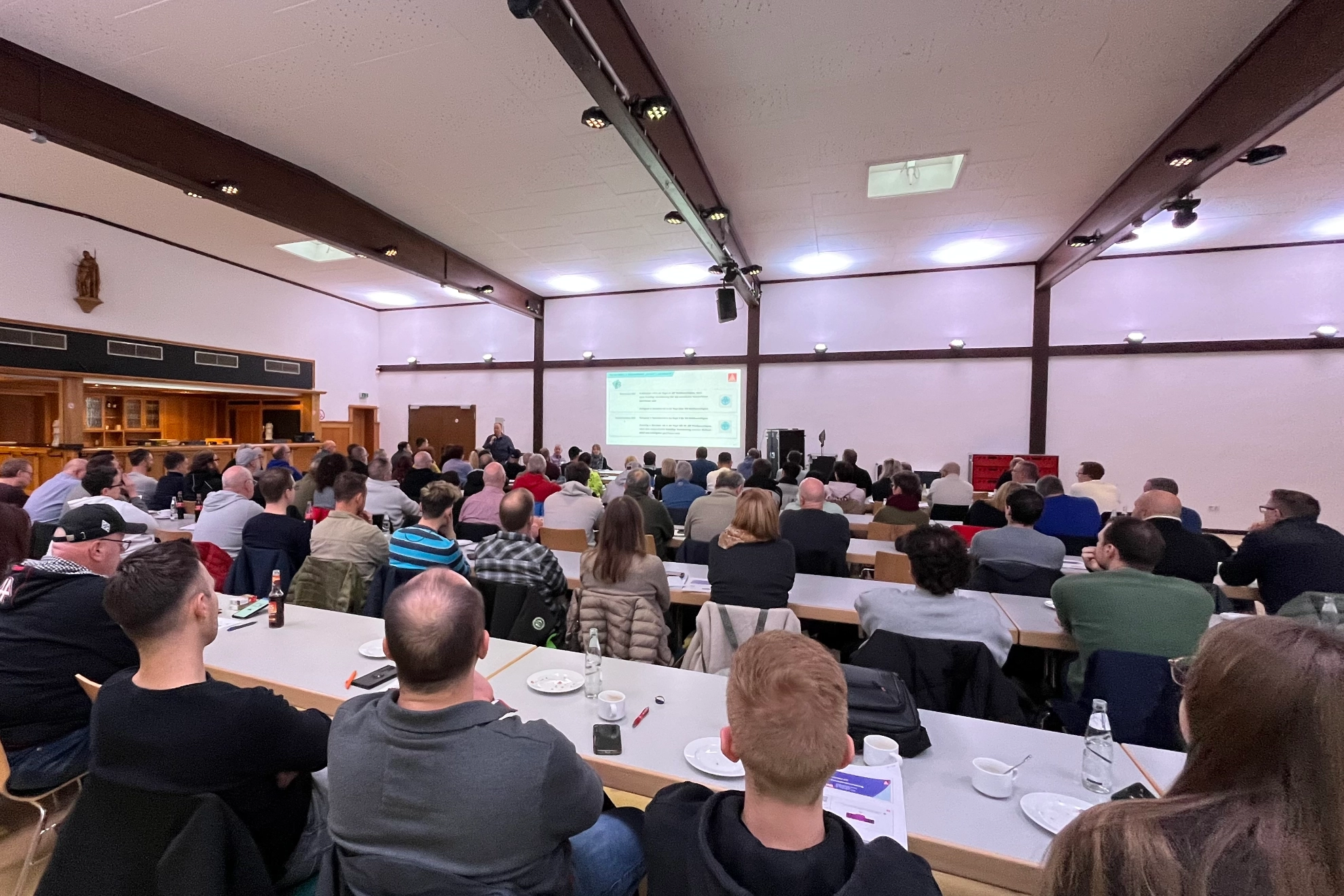 Ein Raum voller Menschen die Andre Arenz bei seinem Vortrag zuhören