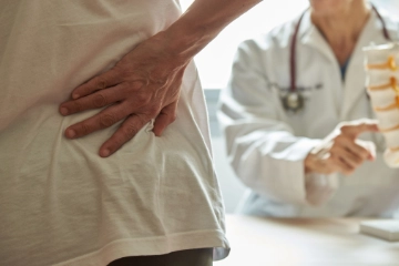 Orthopäde erklärt Patienten die Ursache seiner Rückenschmerzen