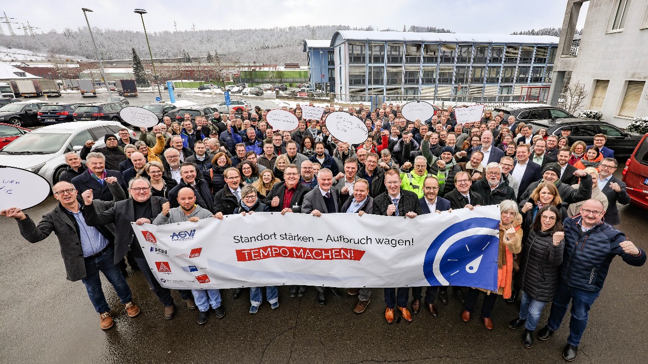 Die Teilnehmenden der Veranstaltung halten kampfbereit die Fäuste in die Luft und lachen in die Kamera. Ein Gruppenbild mit 260 Teilnehmenden. Sie halten Sprechblasen hoch und ein Banner mit der Aufschrift 